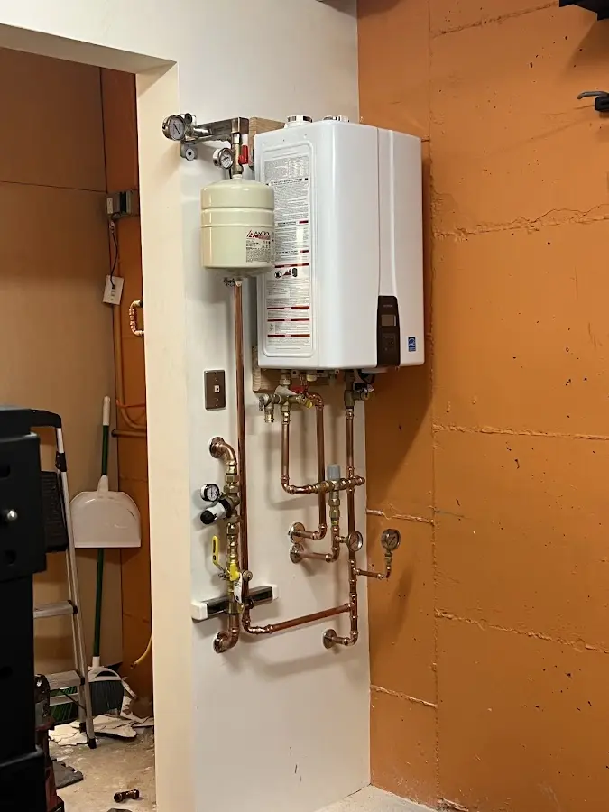 Plumbing technician inspecting water heater connections in Sweeny